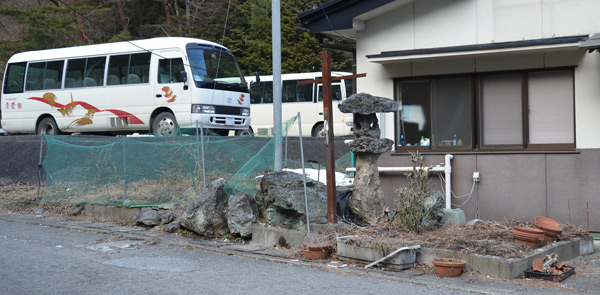 Сад священних каменів біля сучасного готелю для паломників на схилі гори Нішияма Сад священних каменів біля сучасного готелю для паломників на схилі гори Нішияма