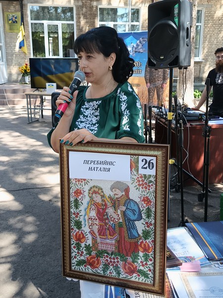 Картину вишивальниці Наталії Перебийніс, яка завоювала Гран-прі конкурсу „Нитки пам’яті, демонструє директорка ЦНСП Любов Тереховська